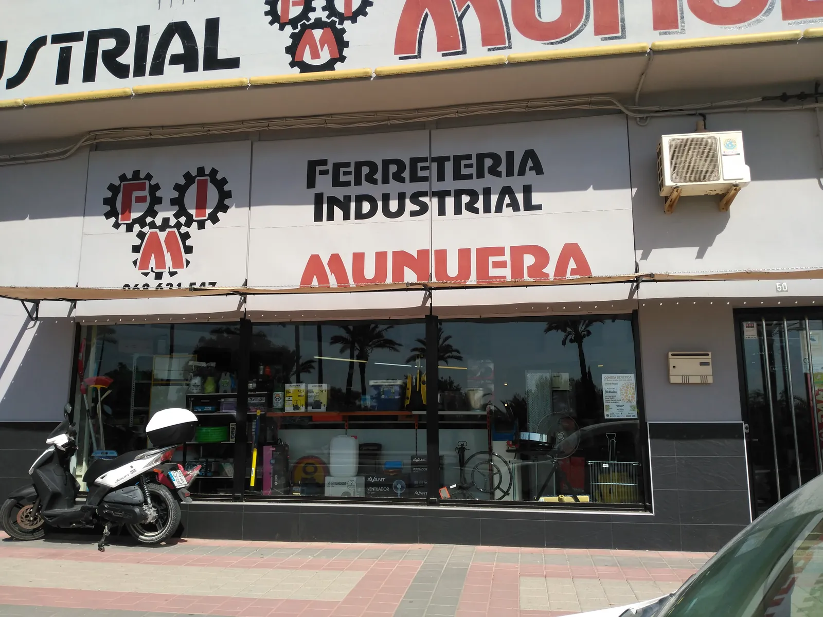 Fachada de Ferretería Industrial Munuera con el rótulo de los engranajes FIM en Av. Antonio Fuertes, Alhama de Murcia